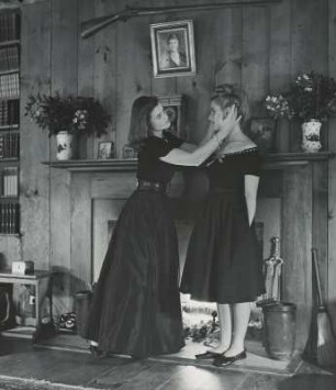 Modeaufnahme, Modelle Ann Whitney und Ann Simkins vor einem Kamin