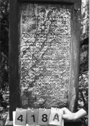 Grabstein 418 (Index: 99752687) Material: Sandstein Zustand: abgeblättert mit Textverlust Maße HxBxT: 147x50x35 cm Beschreibung: Stele, Sockel, Abdeckplatte mit Aufsatz, rechteckiges Schriftfeld eingetieft: Grabstein 418A