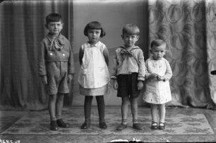 Vier Kinder, wohl Geschwister, im Fotostudio