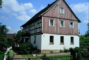 Wohnhaus mit Vorgarten; OG Giebelseite verbrettert
