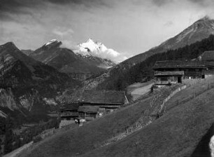Heiligenblut (Kärnten). Ortsteilansicht mit Bauernhöfen. Blick gegen Großglockner von Südosten
