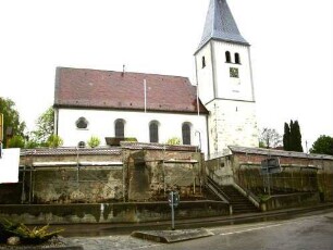 Ansicht von Süden mit Kirche (Kirchturm im Kern Romanisch mit Schießscharten - Glockenstube und Dach sowie Langhaus 1786 neu erbaut) über Kirchhofmauer (Wehrgang im 18 Jh abgetragen)