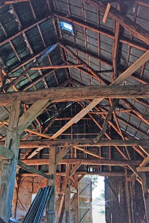 Dorfplatz (2): Fachwerkscheune: Sanierung: Innenansicht: nach Entkernung: Ständergerüst, Dachstuhl: hinten Scheunentor, oben Blechverkleidung: Juli 1994
