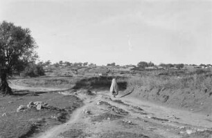 Höhlenwohnungen bei Garian : Hügelige Landschaft mit Hütten und Person