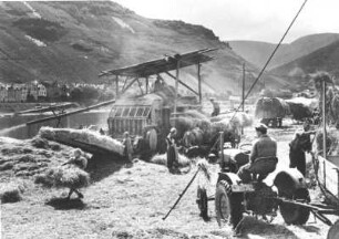 Bauern dreschen Getreide an der Mosel. 1951 wird noch eine stationäre Dreschmaschine mit Strohpresse genutzt