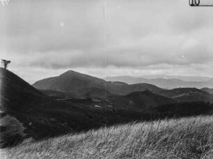 Landschaft : Blick von einer Anhöhe in ein Tal und auf bergige Umgebung