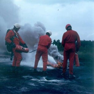 Fallschirmspringer (Angehörige der Freiwilligen Feuerwehr) bekämpfen einen Brandherd mit Spezialfeuerlöschern