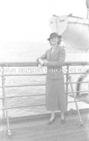 Dame an Deck des Hochseepassagierdampfers "Bremen", an der Reling lehnend