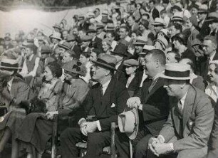 Franklin D. Roosevelt, Mrs. Roosevelt und Konsul Schwarz unter den Zuschauern im Trainingscamp von Max Schmeling in Kingston. Mitte mit Brille: Franklin D. Roosevelt, links: Mrs. Roosevelt, rechts neben Roosevelt: Konsul Dr. Paul Schwarz