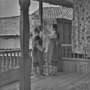 Veranda eines Wohnhauses in Bansko. Frauen beim Tracht anlegen