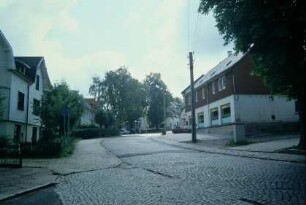gepflasterte Dorfstraße, beidseitig Gebäude