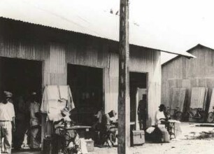 Duala (Douala), Kamerun. Eingeborene Handwerker an Nähmachinen vor einer Faktorei