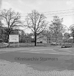 Möllner Landstraße: hinten Einmündung der Bahnhofstraße: ehemalige "Schweinewiese" mit Bäumen: hinten rechts Rathaus und Bürgerhaus Glinde [später Marcellin-Verbe-Haus]: links Bauschild für Geschäfthaus der Kreissparkasse Stormarn: daneben Straßenschilder