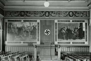 Aula, Gymnasium Dresden-Neustadt : Dresden-Neustadt, Staatliches Gymnasium Dresden-Neustadt. Aula, Ostwand mit Wandmalerei (1882-1884). Links: Abschied Barbarossas in Regensburg vor der Ausfahrt ins heilige Land und rechts: Bibelrevision zu Wittenberg 1541 durch Luther, dazwischen Banner mit Hakenkreuz, Rednerpult und zwei Büsten, wohl Hitler und Hindenburg, auf Stelen