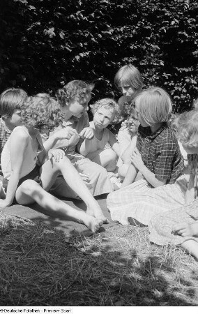 Büchereiangestellte Krüger der Stadtbücherei Mitte liest Kindern aus einem Buch vor