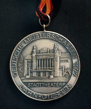 Silbermedaille Deutsche Meisterschaften in Kurzschrift und Maschinenschreiben in Gießen 1977 am schwarz-rot-goldenen Band : Sammlung Deutscher Stenografenbund. Silbermedaille Deutsche Meisterschaften in Kurzschrift und Maschinenschreiben in Gießen 1977 am schwarz-rot-goldenen Band. Messing, versilbert; Durchmesser 50 mm, Gewicht 51 g (1977; Deschler & Sohn, München). Dresden: SLUB R c 0525
