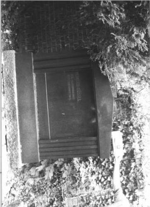 Grabstein 60 (Index: 100108883) Material: polierter Granit auf Granit, Metallbuchstaben Zustand: sehr gut Maße HxBxT: 161x165x24 cm Beschreibung: Monument Besonderheit: Doppelgrab, nur linke Seite beschriftet: Grabstein 60