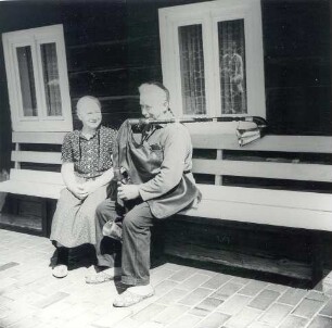 Ehepaar mit Dudelsack : Volksmusik - Interpreten und Instrumente. Ort: Trjebin/ Trebendorf. Dudelsackspieler Hanzo Schuster mit Ehefrau vor seinem Wohnhaus aus Holz, 1980