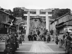 Nagasaki. Erwachsene und Kinder in traditioneller Kleidung auf den Stufen zum Eingang des Asura-Tempels