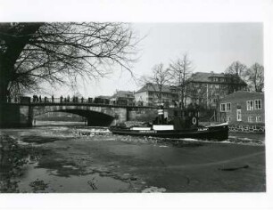 Hamburg-Uhlenhorst : Hamburg-Uhlenhorst. Winter. Ein Eisbrecher auf dem Mundsburger Kanal . Er bricht eine Fahrrinne. Zuschauer schauen von der Kuhmühlenbrücke neugierig zu