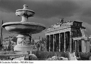 Berlin. Blick über die zerstörte südliche Springbrunnenanlage am Hindenburgplatz nach Nordosten zum Brandenburger Tor