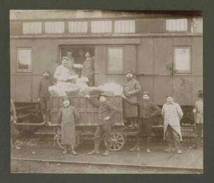 10 Kriegsgefangene laden Pakete aus einem Eisenbahnwaggon auf einen Wagen, zwei Wachhabende, Kriegsgefangenenlager Ludwigsburg-Eglosheim