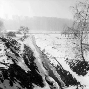 Mühlenbach: stillgelegter Ausbau: links Erdhaufen: rechts Baum: hinten Wald: Winter