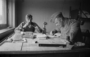 Zweiter Weltkrieg. Niederlande unter deutscher Besatzung. Zwei Wehrmachtsangehörige in der Unterkunft beim Briefeschreiben (wohl bei Den Haag)