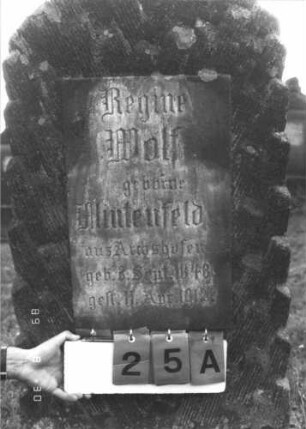 Grabstein 25 (Index: 99609661) Material: Sandstein Zustand: verwittert, Schriftplatte fehlt Maße HxBxT: 141x63x27 cm Beschreibung: Stele, Korbbogenabschluß, eingelassene Schriftplatte rechteckig (fehlt), Sockel Symbolik: zwei Zweige, Gürtel? (Band?): Grabstein 25A