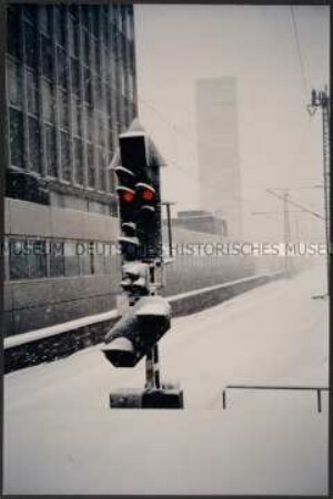 Signallicht im verschneiten Essener Bahnhof mit Hochhaus im Hintergrund (Altersgruppe 14-17)