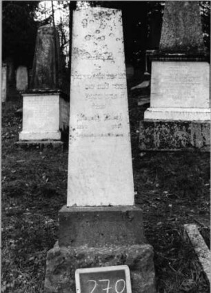 Grabstein 270 (Index: 100090145) Material: weißer Marmor, Sockel Granit Zustand: gut Maße HxBxT: 138x39x13 cm Beschreibung: Obelisk, getreppter Sockel: Grabstein 270