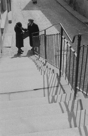 Zwei sich unterhaltende Personen am Fuß der Treppe zum Burgberg in Meißen