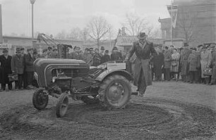 Ein Messebesucher testet auf dem Außengelände einen Allgaier-Porsche-Diesel-Schlepper der Firma Porsche-Diesel-Motorenbau GmbH