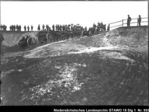Besichtigung des Feld-Artillerie-Regiments Nr. 46 Enthält: Soldaten auf mit Pferden bespannten Geschützlafetten fahren auf einem Weg eine Anhöhe hinauf, auf der Anhöhe: Zuschauer