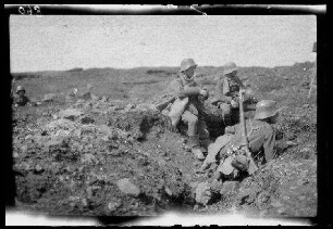 Übungsgelände I bei Mouzon (Dep. Ardennes, Frankreich): 3 Soldaten mit Stahlhelm bei einer Pause am Rand eines Grabens (Seitansicht, Nahaufnahme) ("im Graben")