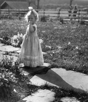 Kinderbilder. Kleines Mädchen auf einem Gartenweg