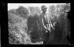 Bei Namur (Belgien): Soldat mit Stahlhelm und "mit Hund" in einem Graben (Vorderansicht, Nahaufnahme)