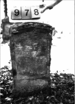 Grabstein 978 (Index: 99751383) Material: Sandstein Zustand: stark verwittert Maße HxBxT: 83x38x13 cm Beschreibung: Stele, giebelartiger Abschluß mit Verdachung, Schriftfeld eingetieft: Grabstein 978