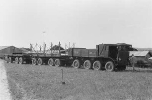 Lastkraftwagen mit Anhänger : Lastkraftwagen mit zwei Aufliegern vor einer Fabrik.