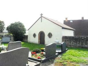 Friedhof-Ansicht im Südosten mit oberem Teil des Bahrhauses (Tür mit profiliertem Gewände) sowie anschließender Kirchhofmauer (Wehrgang mit Steinbrüstung im 18 Jh abgetragen)