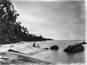 Person am Strand : Eine sitzende Person an einem Strand
