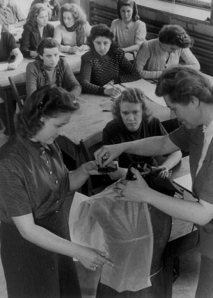 Fachschule für Konfektionsgewerbe Hamburg Uferstraße. Die Schülerinnen drapieren die Puppe mit den zugeschnittenen Papierteilen. Aufgenommen 1949