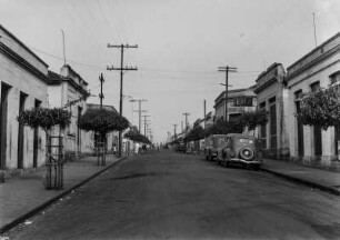 Hauptstraße von Monte Aprazivel : Die Hauptstraße von Monte Aprazivel mit Autos am Straßenrand und Bäumen auf den Bürgersteigen.
