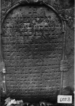 Grabstein 605 (Index: 99753117) Material: Sandstein Zustand: verwittert Maße HxBxT: 109x65x11 cm Beschreibung: Stele, eingezog. Kielbogenabschl. , Schrift eingetieft mit eingezog. Rundbogenabschl. Symbolik: Blätter, Schriftband: Grabstein 605B