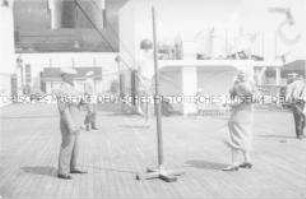 Passagiere an Deck des Hochseepassagierdampfers "Bremen", Swingball-Tennis und Bordshuffle spielend