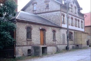 Backsteingebäude mit verschiedenfarbigen Steinen; Laderampe an Nebengebäude