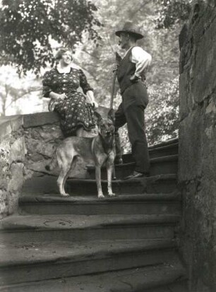 Paar mit Schäferhund auf einer Treppe