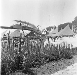 Lausanne (Schweiz). Freizeitpark (?). Blick gegen eine Hochbahn mit der Aufschrift "Campari", die durch den Park fährt