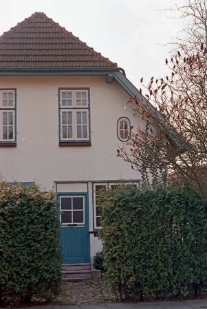 Hasselbusch 7: giebelständiges Wohnhaus: Straßenfront, Teilansicht mit Eingangstür: im Vordergrund Gartenhecke