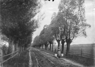 Unbefestigte Landstraße mit Wasserträgerin (vielleicht in Niedersachsen)